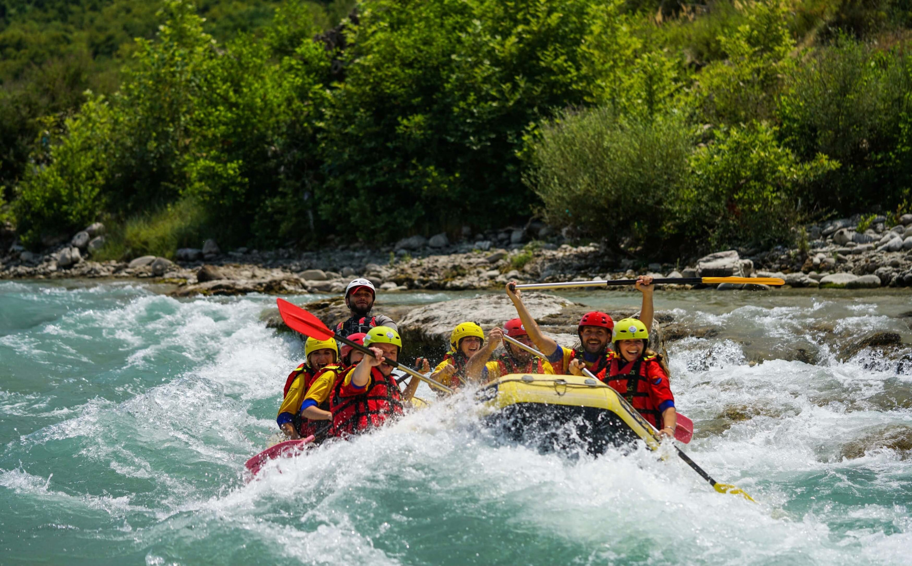 Ljudi veslaju u čamcu za rafting